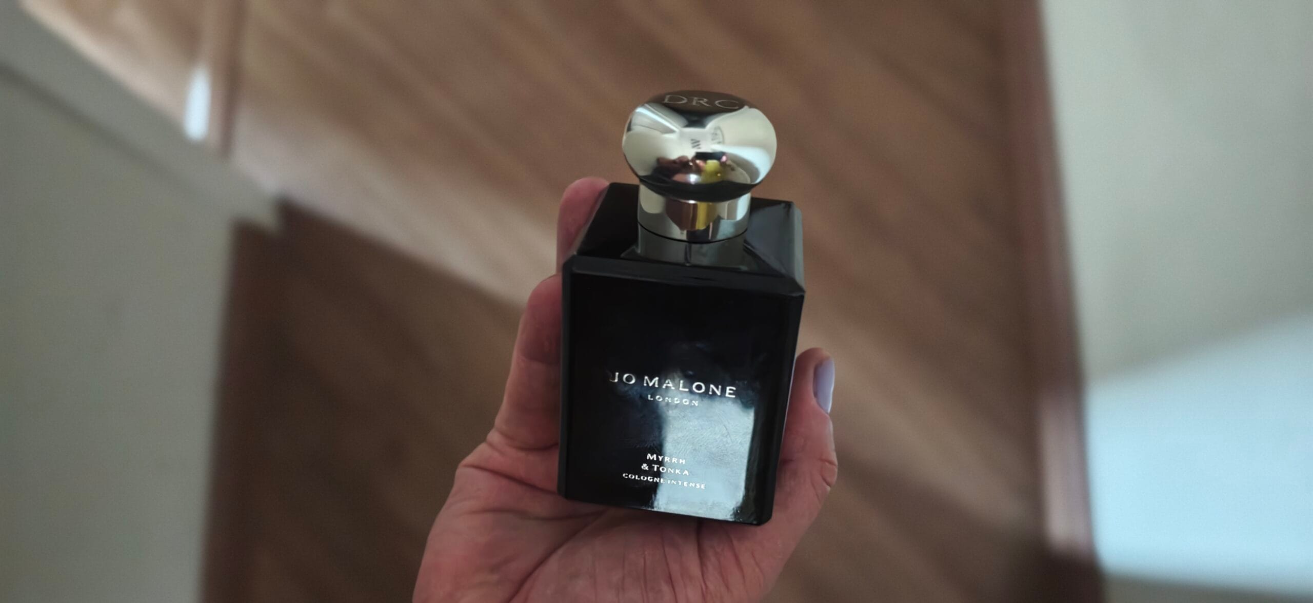 Jo Malone Myrrh & Tonka Cologne Intense bottle — angle showing the dark amber liquid